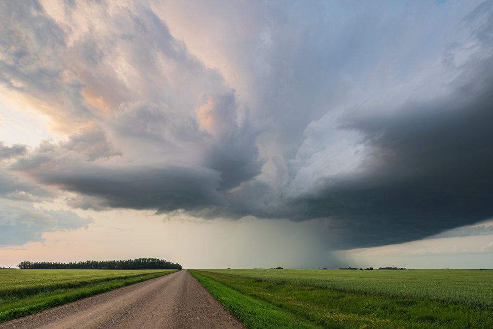 Storm Supercell with dark rain clouds and rainfall over fields along Range Road 43, Storm Chasing, Weather, Environment, Rocky View County, Saskatchewan, Canada.