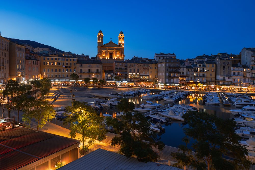 Old Port of Bastia with the illuminated Church of St John the Baptist and moored boats at twilight, Travel Photography, Corsica, France.