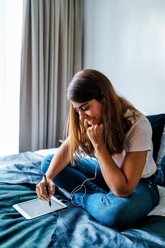 A woman using a digital pen on a tablet