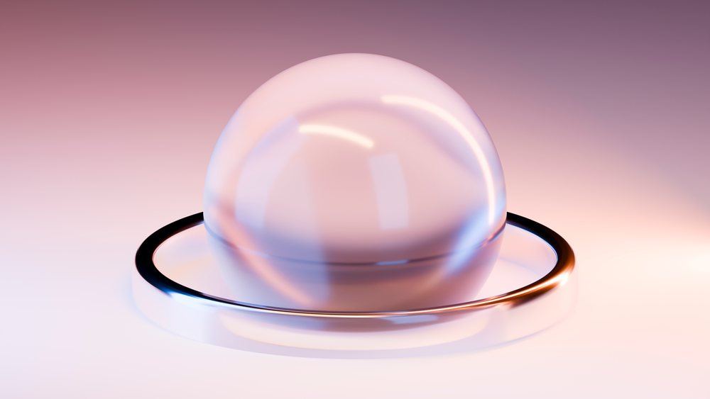 Glass sphere resting inside a reflective metal ring with soft lighting and a gradient background in a studio setting.