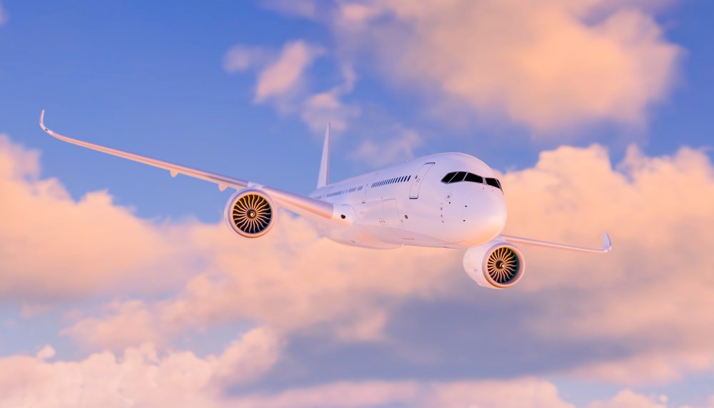A modern commercial airplane flying in the sky among clouds during a sunset, travel, fly, vacation.