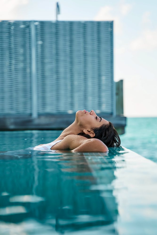 A white woman relaxing in a swimming pool at a resort