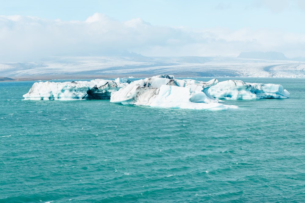 Large floating icebergs in a glacier lagoon surrounded by snowy mountains, Iceland.
