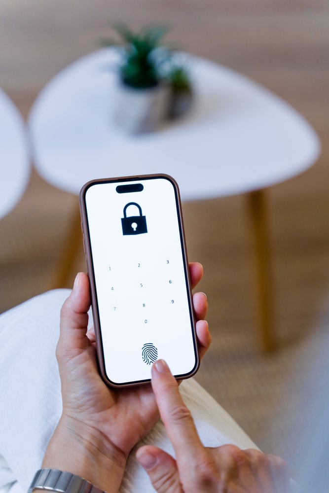 Person unlocking a smartphone by using fingerprint authentication on the locked screen with biometric security features, Spain.