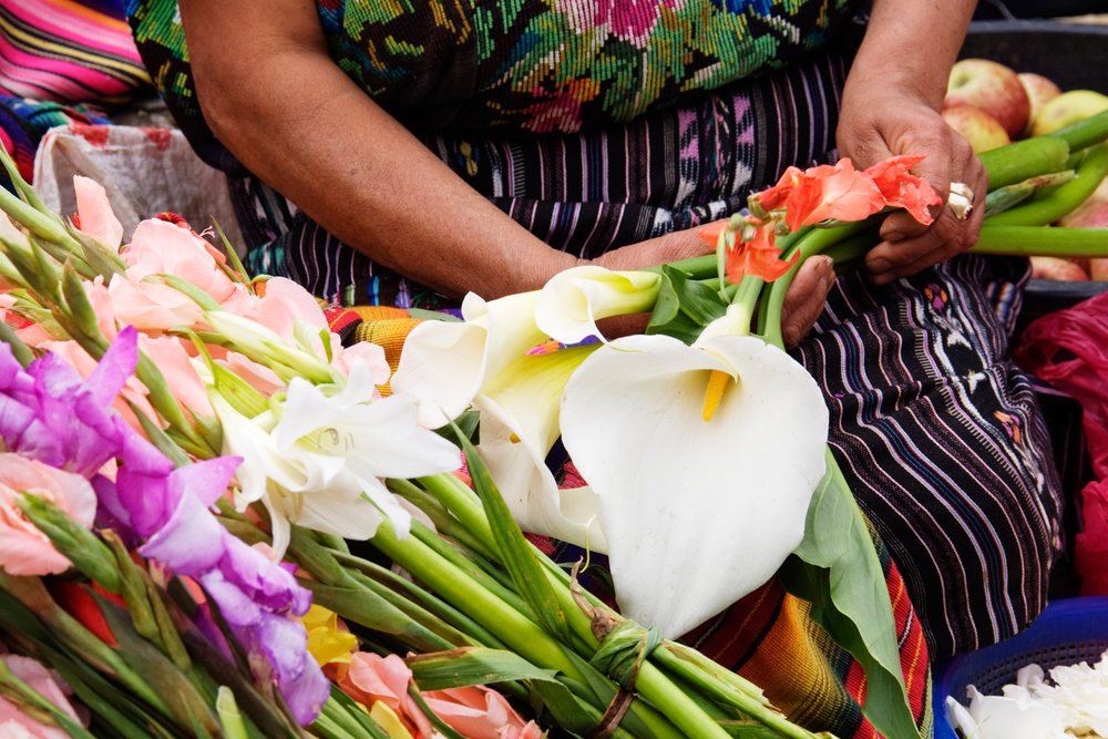 Woman selling colorful calla lilies and gladiolus flowers, Market, Chichicastenango, Guatemala.