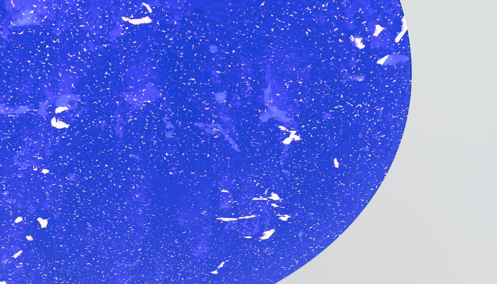 Blue terrazzo surface with white and pinkish stone chips and smooth finish.