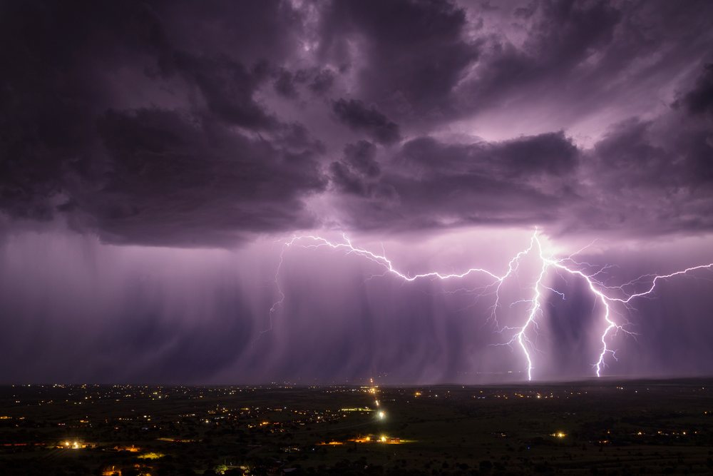 Lightning bolts strike during a nighttime thunderstorm over Sierra Vista beneath dark storm clouds, Storm Chasing, Weather, Environmental Issues, Arizona, USA.