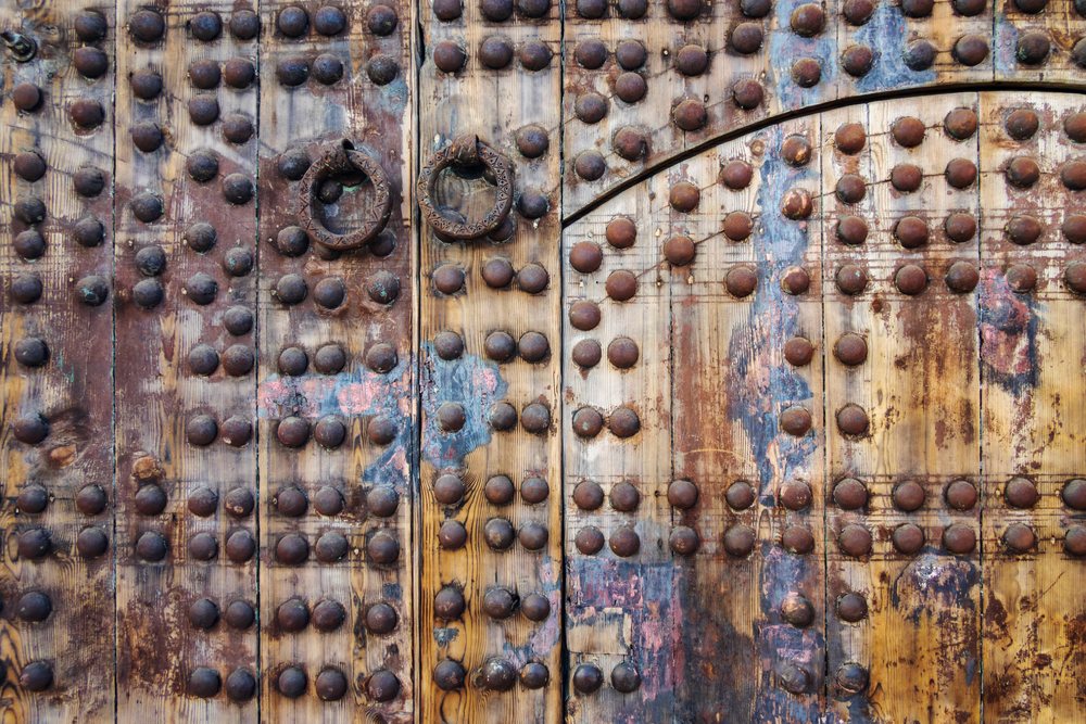 Ancient wooden door with ornate metal studs and ring knockers, Morocco's, Lifestyle, Landscape, Culture, Marrakech, Marrakesh-Safi Region.