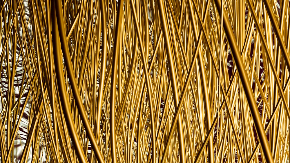 Golden thin metal rods arranged in an intricate, dense abstract pattern with a shiny reflective surface.