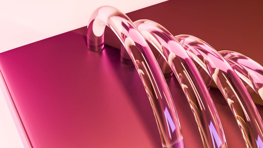 Abstract pink transparent glass tubes looped and curved over a shiny smooth pink reflective surface with colorful highlights.