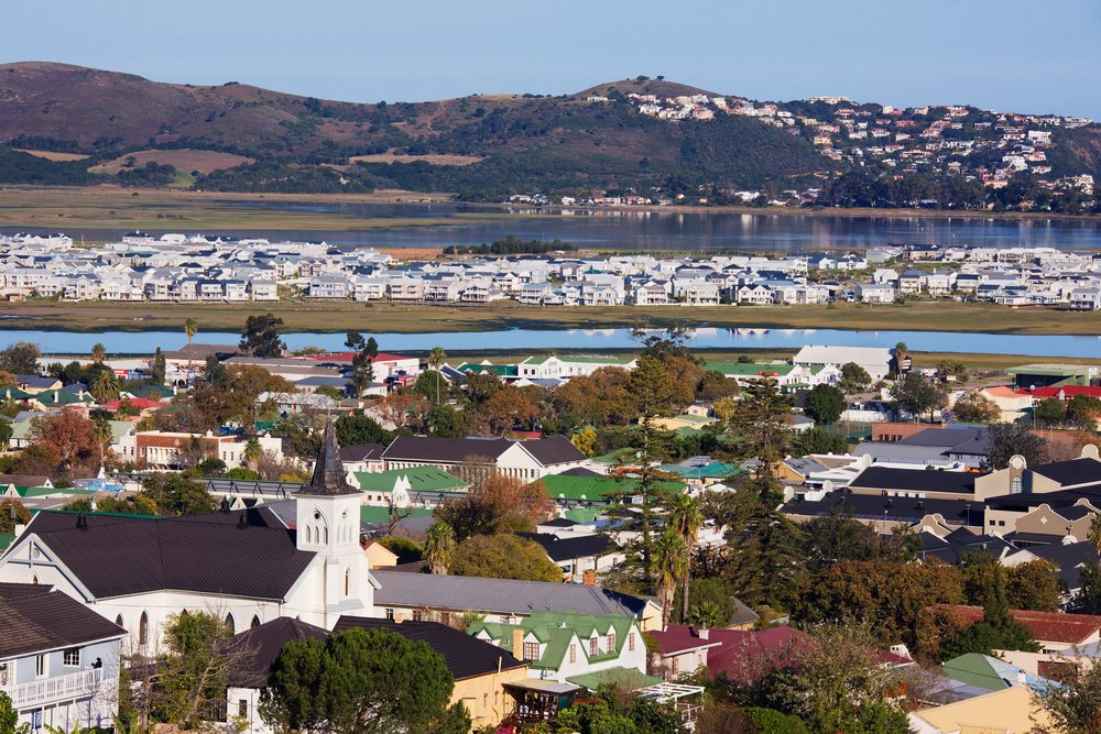 Panoramic view of Knysna town with river, hills, and a church steeple, Western Cape, South Africa.
