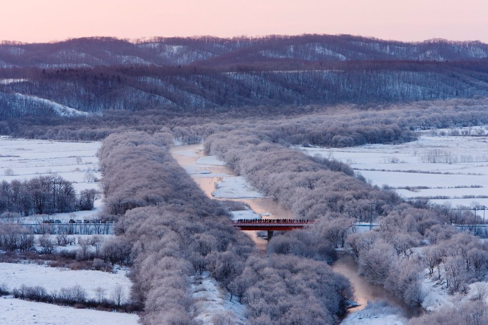 Bridge spans a partially unfrozen river, Hokkaido, Japan.