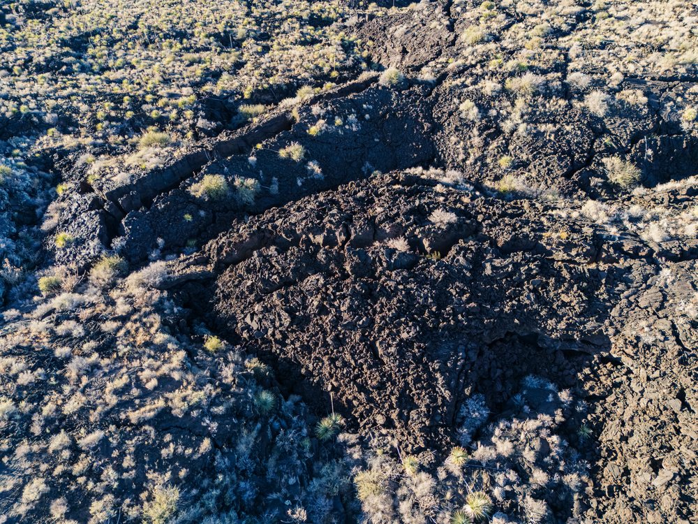 Aerial view showing a rugged volcanic Lava Field with dry desert shrubs, landscape, wildlife, Carrizozo, New Mexico, USA.