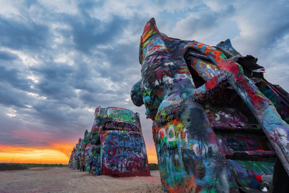Cadillac Ranch art installation with colorful spray-painted cars at sunrise, Storm Chasing, Amarillo, Texas, USA.