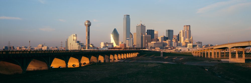 Dallas skyline with Trinity River and bridges at sunset showing urban structures and clear sky, Dallas Trinity River Texas, USA.