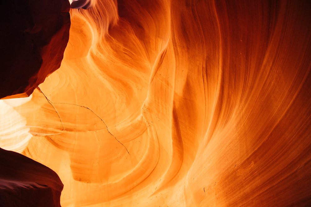 Natural light illuminates the curved orange sandstone walls of Antelope Canyon slot canyon, Navajo Land, Arizona, USA.