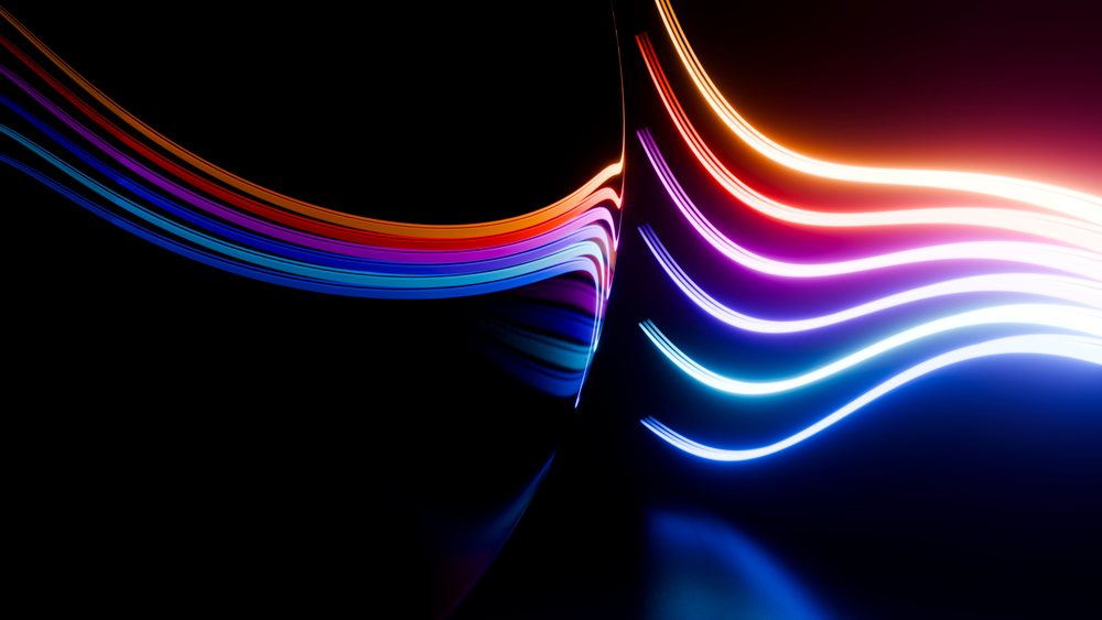 Curved colorful light streaks on a dark background create an abstract glowing wave pattern in digital art.