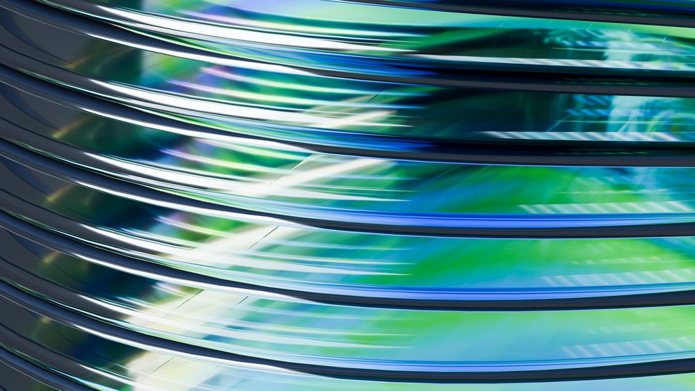 Abstract digital 3D illustration of shiny metallic curved lines with blue and green reflections forming a smooth wave pattern.