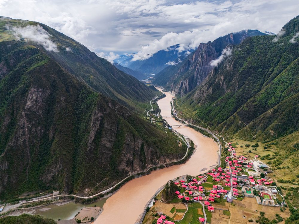 Jinsha River flows through mountainous terrain with Gangtuocun village, Sichuan Province, People's Republic of China.