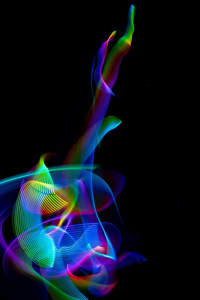 Colorful light painting with led lights creating abstract flowing trails on a black background, Germany.