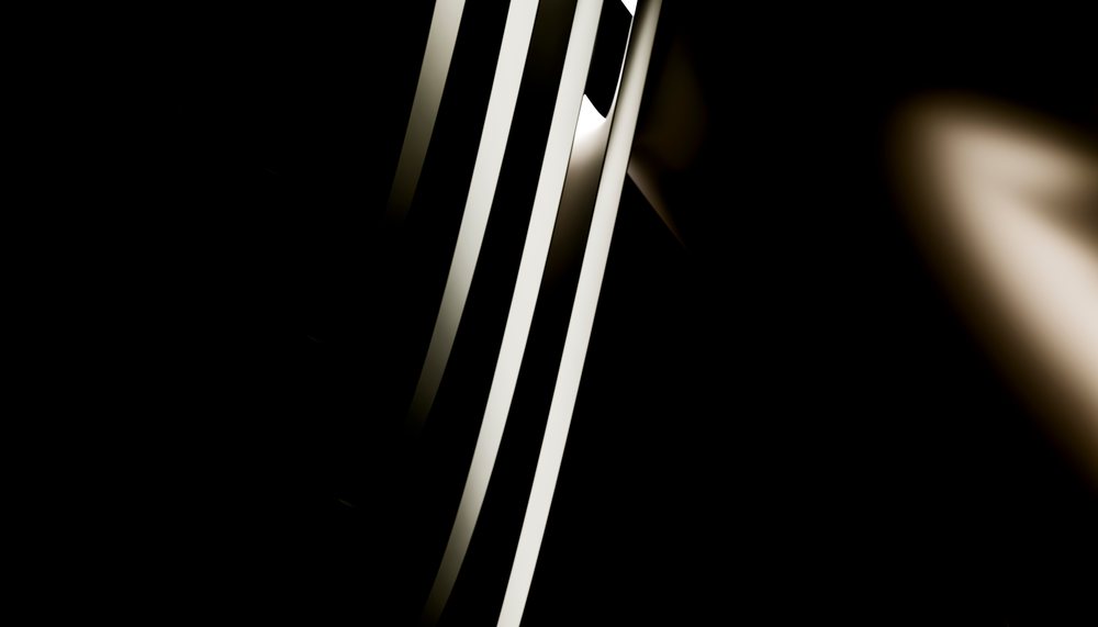 Abstract vertical light rays with high contrast against a dark background creating dramatic shadow effects.