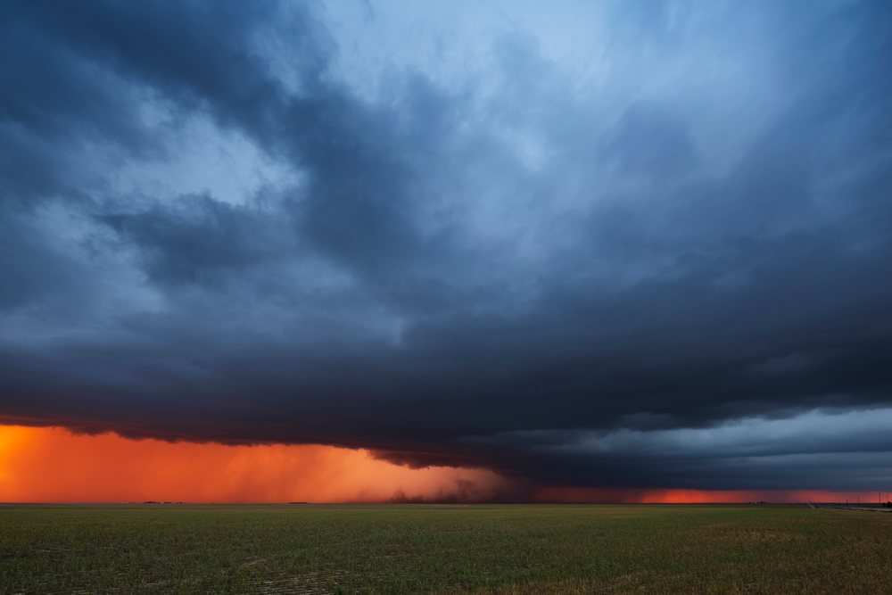 Supercell thunderstorm at Sunset producing RFD Dust over a flat open grassy field, United States, Storm Chasing, Weather, Environmental Issues, Burlington, Colorado.