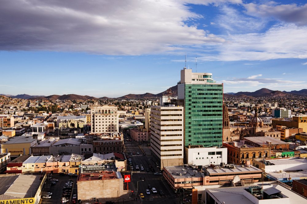 Cityscape of chihuahua with urban buildings and mountain backdrop, Mexico.