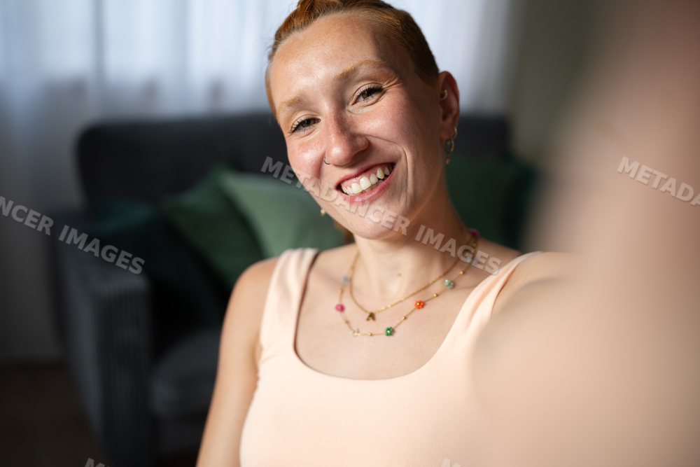 Smiling young white woman taking a selfie at home in Galicia, Spain