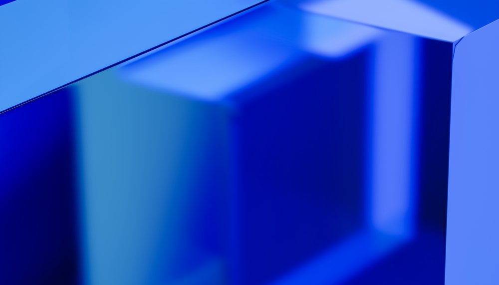 Abstract render showing blue geometric shapes with reflective surfaces and shiny texture in a close-up view.