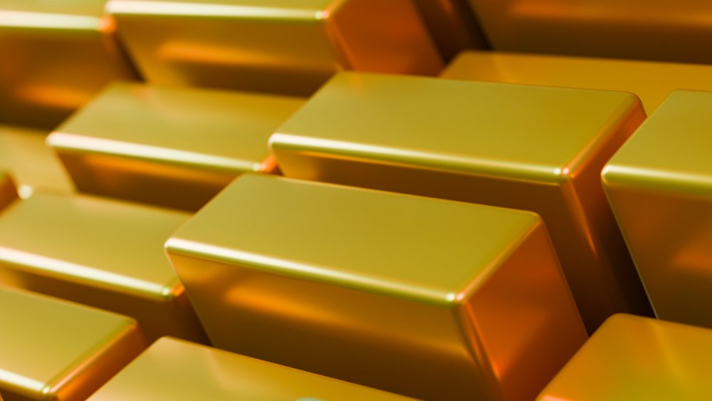 Stacked rectangular gold bars with shiny surfaces create a pattern of valuable precious metal ingots.