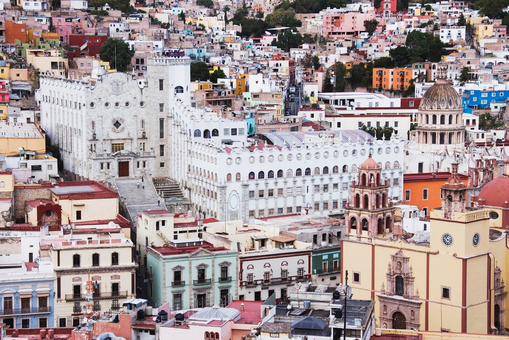 Panoramic cityscape showing historic colonial architecture and colorful buildings on the hilly terrain of Guanajuato, Mexico.