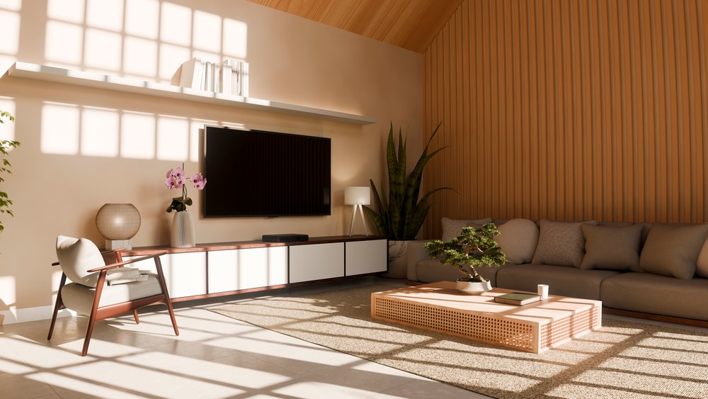 Modern living room interior featuring a wood paneled accent wall, sectional sofa, bonsai on coffee table, armchair, and flat screen television.