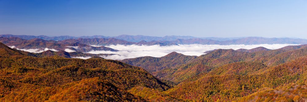 Panoramic view of mountain ridges with autumn foliage and clouds in the Blue Ridge Parkway, Appalachian Mountains, North Carolina, USA.