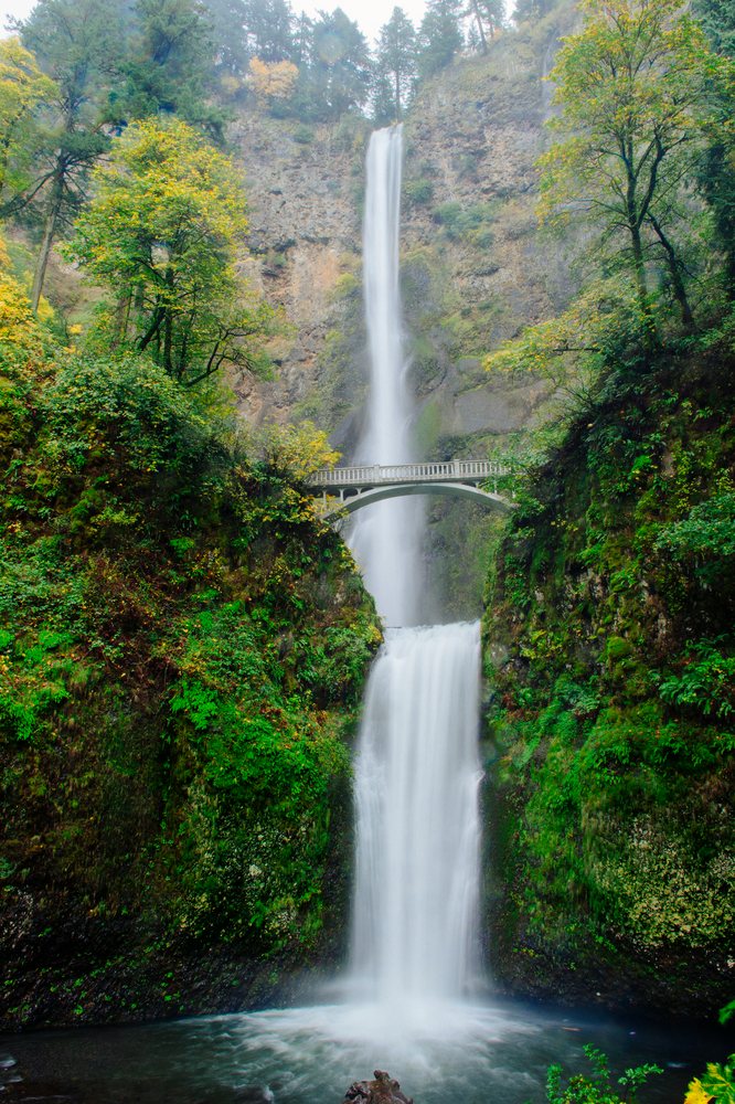 Multnomah Falls cascading over a cliff with a bridge spanning the waterfall, Bridal Veil, Oregon.
