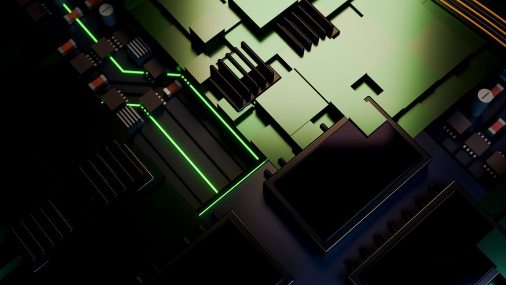 Close-up of circuit board illuminated by green light showing microchips, capacitors, and heat sinks.