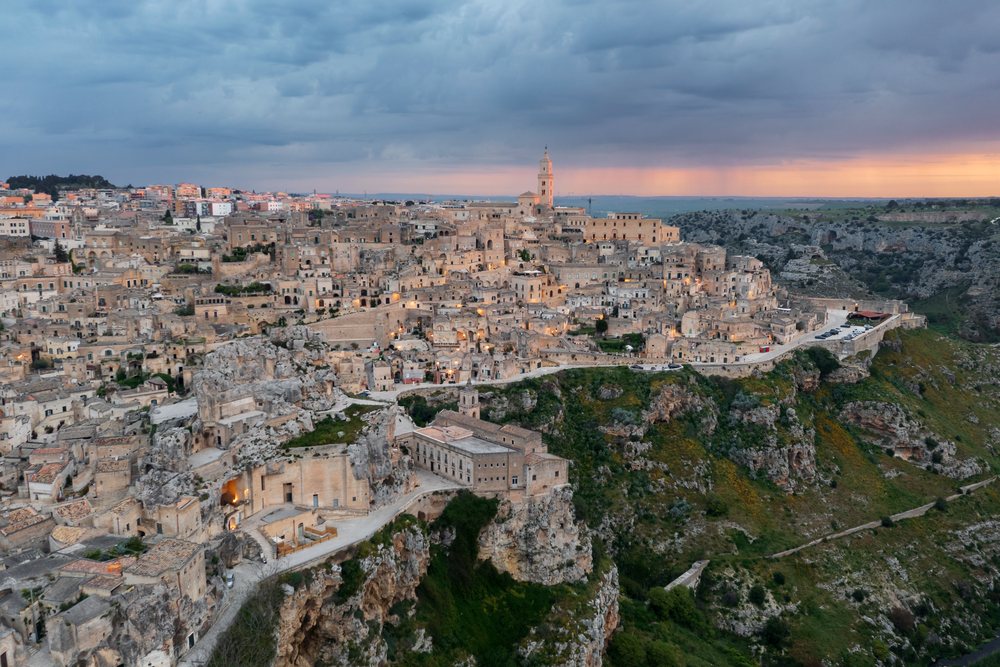 Historic stone buildings on cliffs at Dawn overlook the hilltop town of Sasso Caveoso, Matera, Basilicata, Italy.