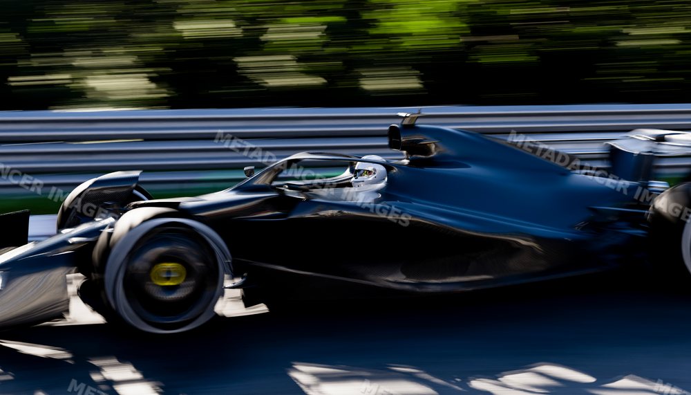 A black race car driven at high speed on a professional race track