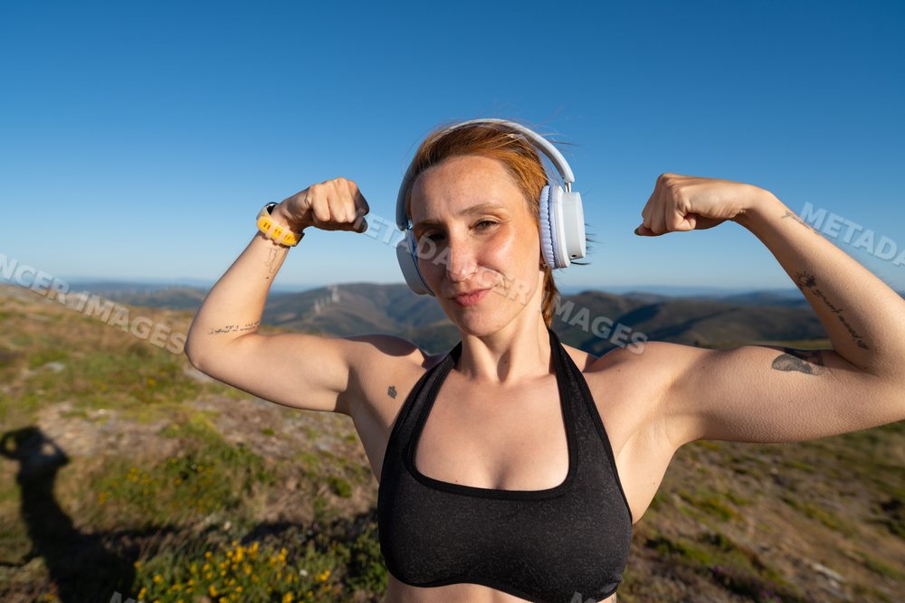 Fit white woman flexes muscles during outdoor workout in Galicia Spain