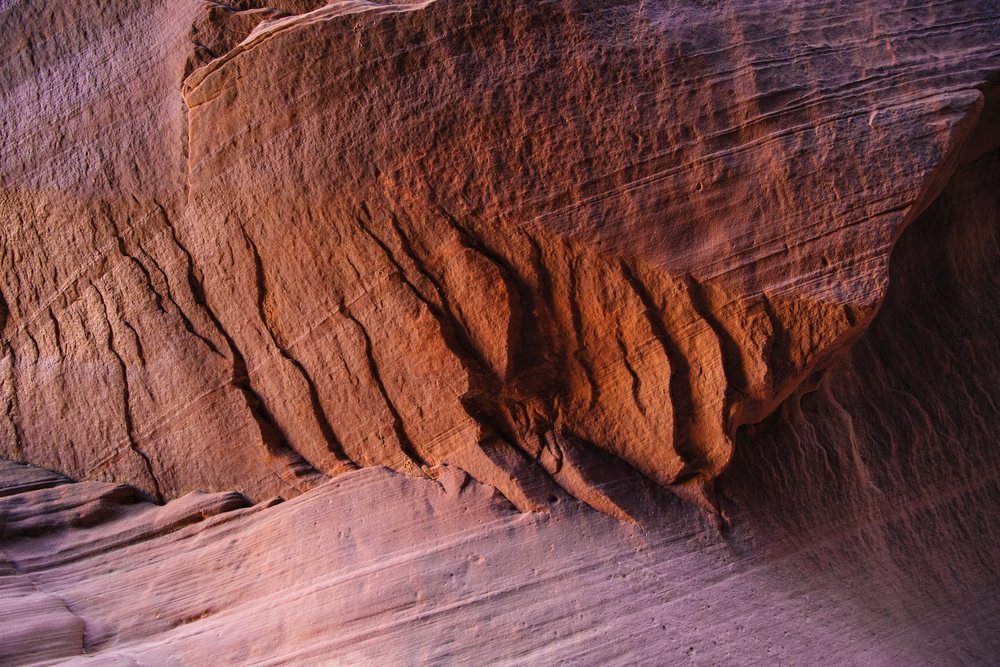 Buckskin Gulch slot canyon in Utah features layered sandstone rock formations with ridges and erosion patterns, USA.
