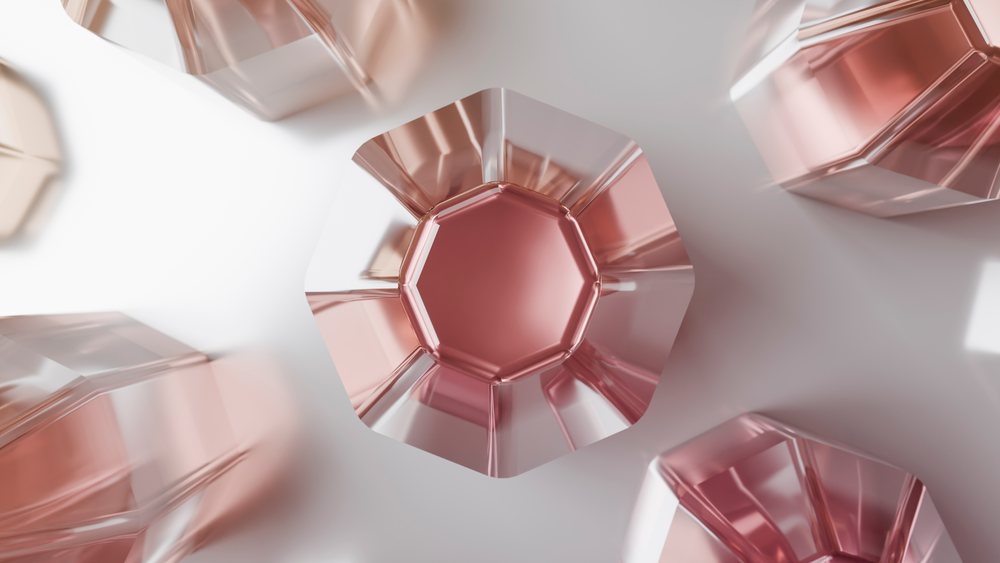 Octagonal pink jelly pieces with shiny translucent texture arranged on a white surface under studio lighting.