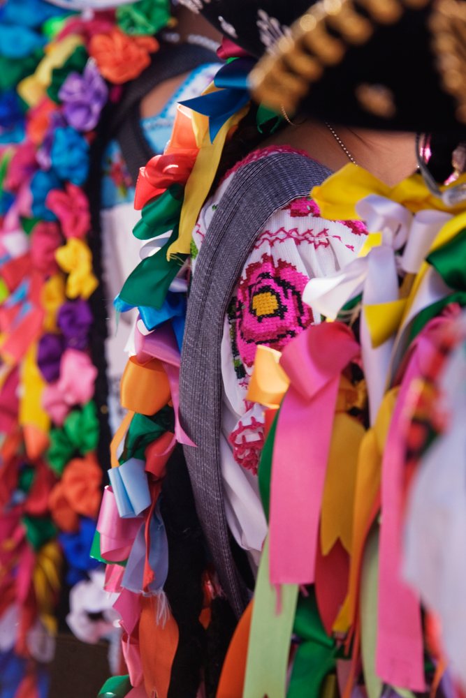 Colorful ribbons and embroidered textiles adorn a folk dress at a festival, Michoacan, Mexico.