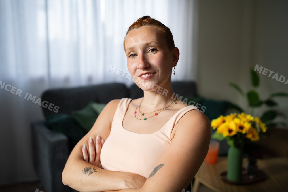 A confident white woman with crossed arms at home in Galicia, Spain