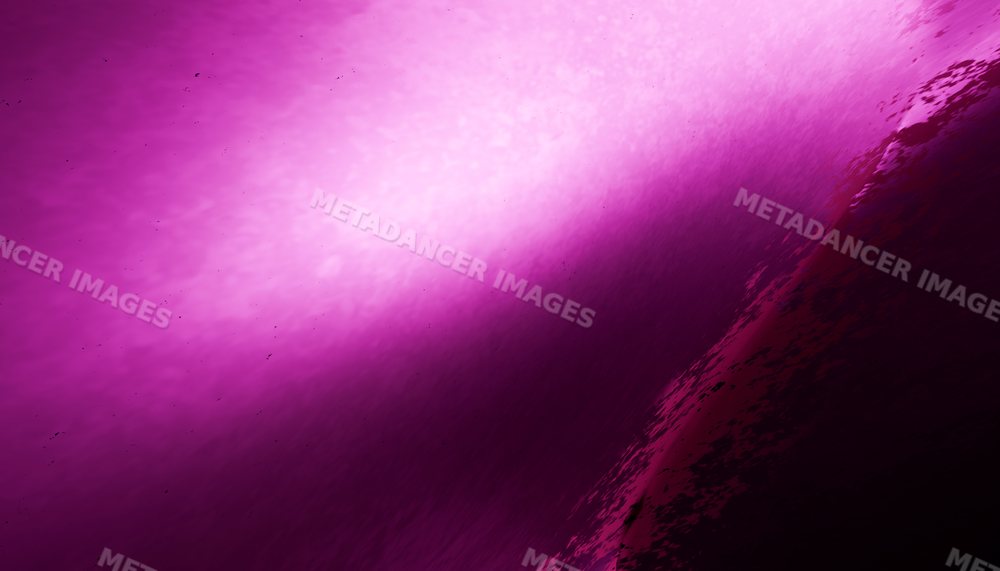 Close-up of a purple ocean wave curling with textured water surface