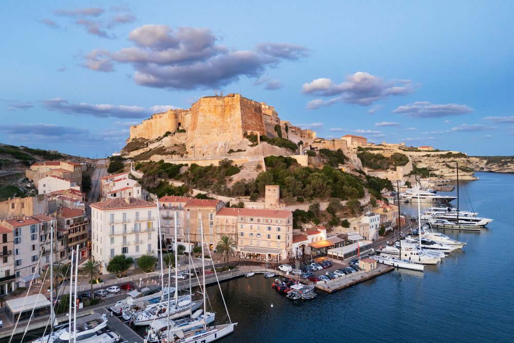 Sunrise over a Harbour with boats and a historic Citadel perched on cliffs, Travel Photography, Bonifacio, Corsica, France.