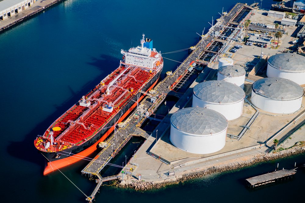 Oil tanker ship docked at petroleum storage tanks and industrial loading facility at the, Port of Long Beach, CA, USA.