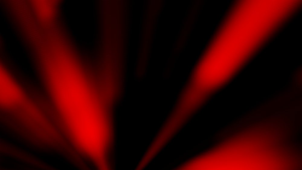 Dynamic abstract image featuring red and black light patterns with blurred effects.
