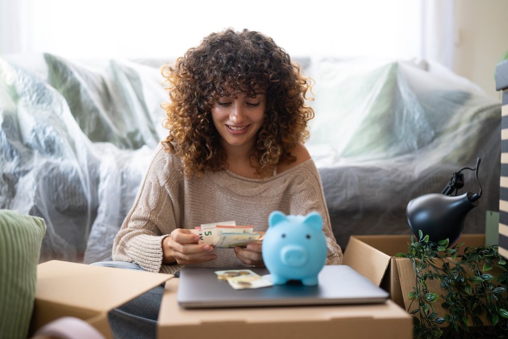 Woman with curly hair counting euro banknotes indoors, moving, Spain.