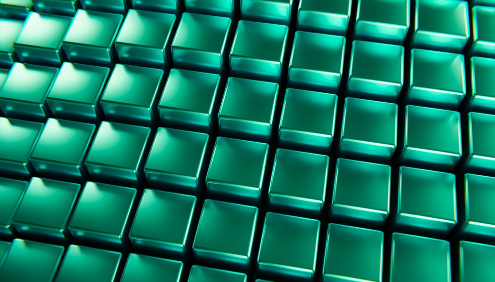Blue-green metallic three-dimensional cubes arranged symmetrically in a grid form an abstract digital background pattern.