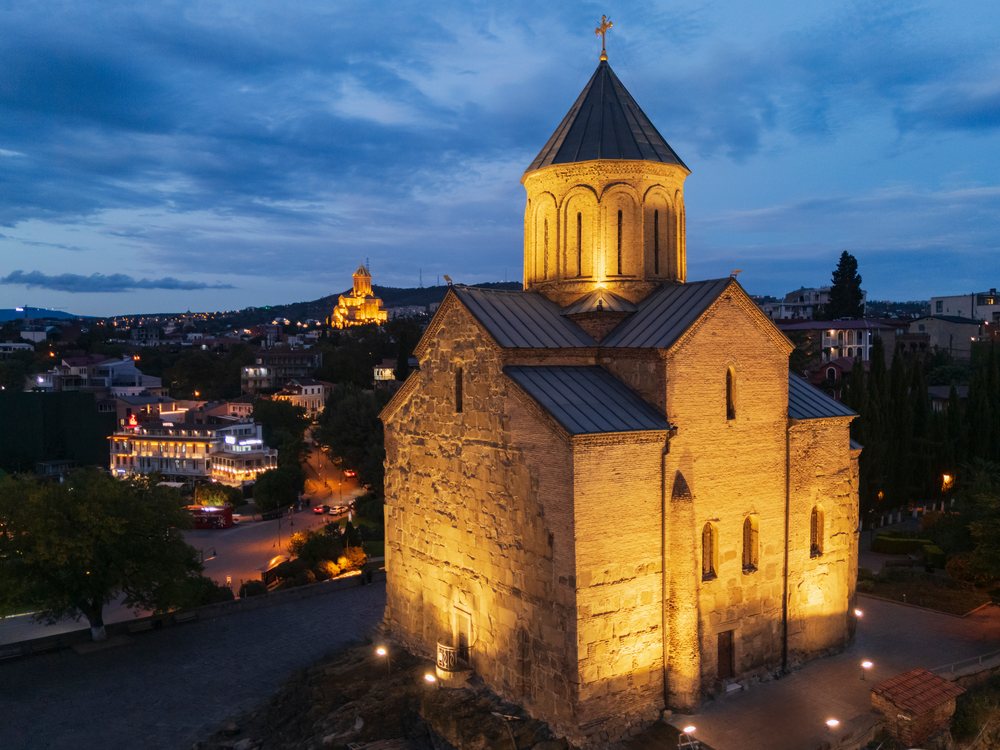 Metekhi Church illuminated at Dusk overlooking the Tbilisi cityscape, Georgia.