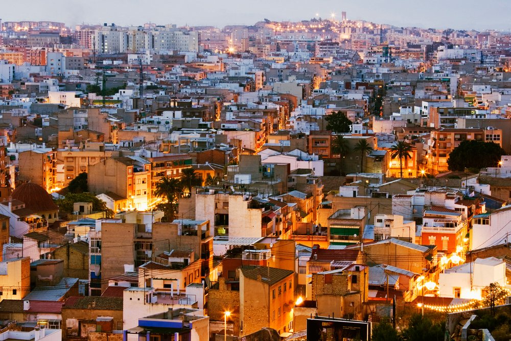 Dusk cityscape showing residential apartment buildings and illuminated streets, Costa Blanca, Spain.